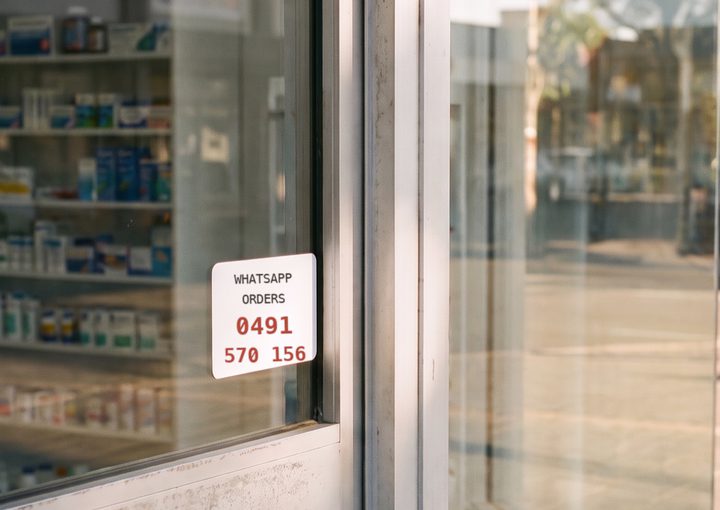 A photo posted on the pharmacy's Google listing: a sticker in the shop window reading WhatsApp orders, 0491 570 156